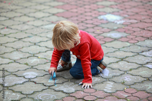 Preschooler child drawing with chalk on sidewalk © endostock