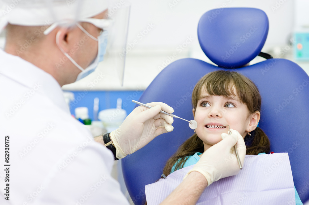 dental examining being given to little girl by dentist dental examining being given to little girl by dentist