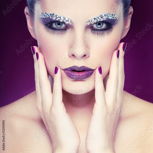 beautiful girl with strasses on face  on a violet