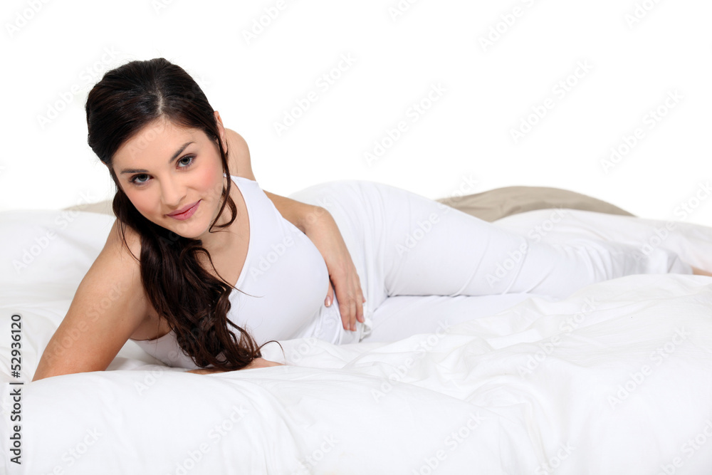 Cute brown-haired woman lying on a bed Cute brown-haired woman lying on a bed