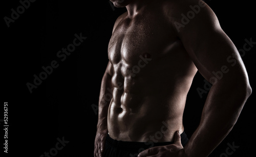 Close up of perfect male body isolated on black background photo