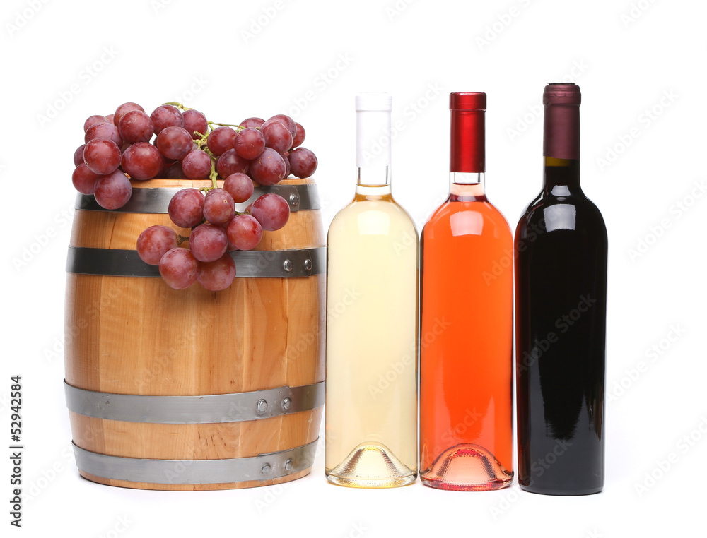 barrel and bottles of wine and ripe grapes on wooden