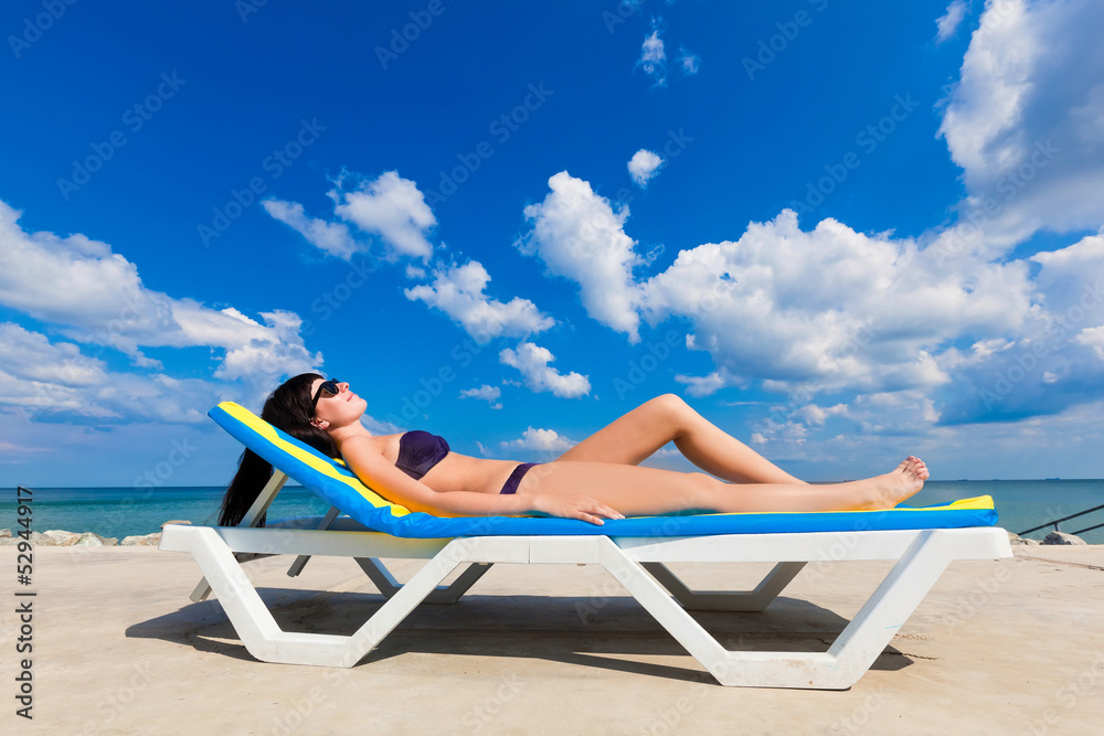 beautiful girl in a bikini lying on a deckchair beautiful girl in a bikini lying on a deckchair