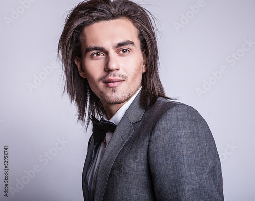 Portrait of handsome long-haired stylish man with bow tie. photo