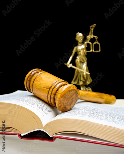 gavel on law book on a black background. vertical photo.
