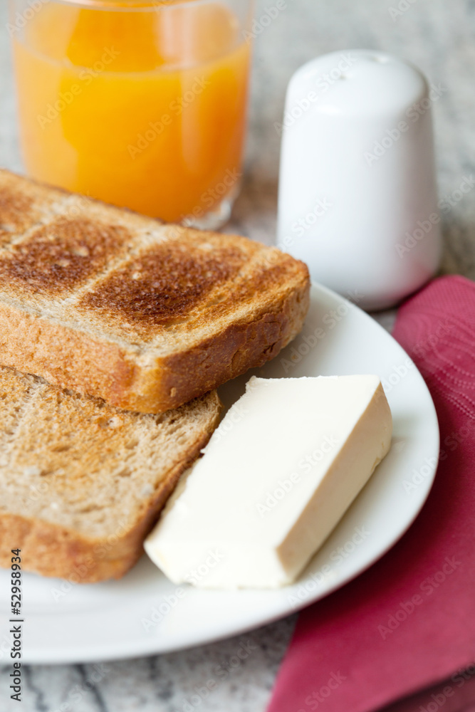 Toast, butter and orange juice for breakfast