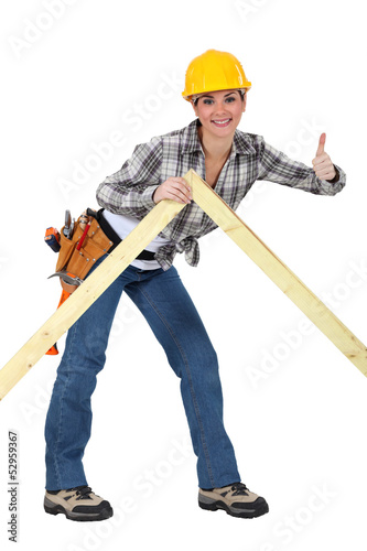 A female carpenter giving the thumb up.