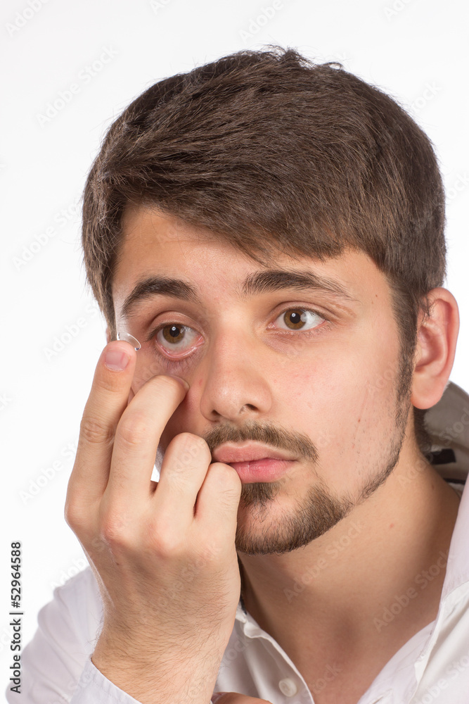Obraz premium Closeup view of a man's brown eye while inserting a corrective c