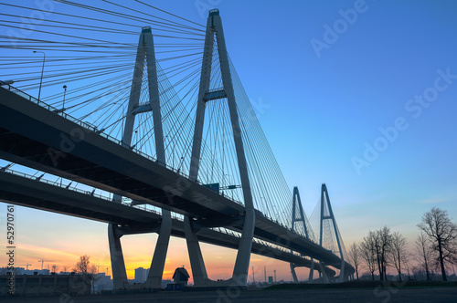 Big suspended bridge during sunrise on blue sky