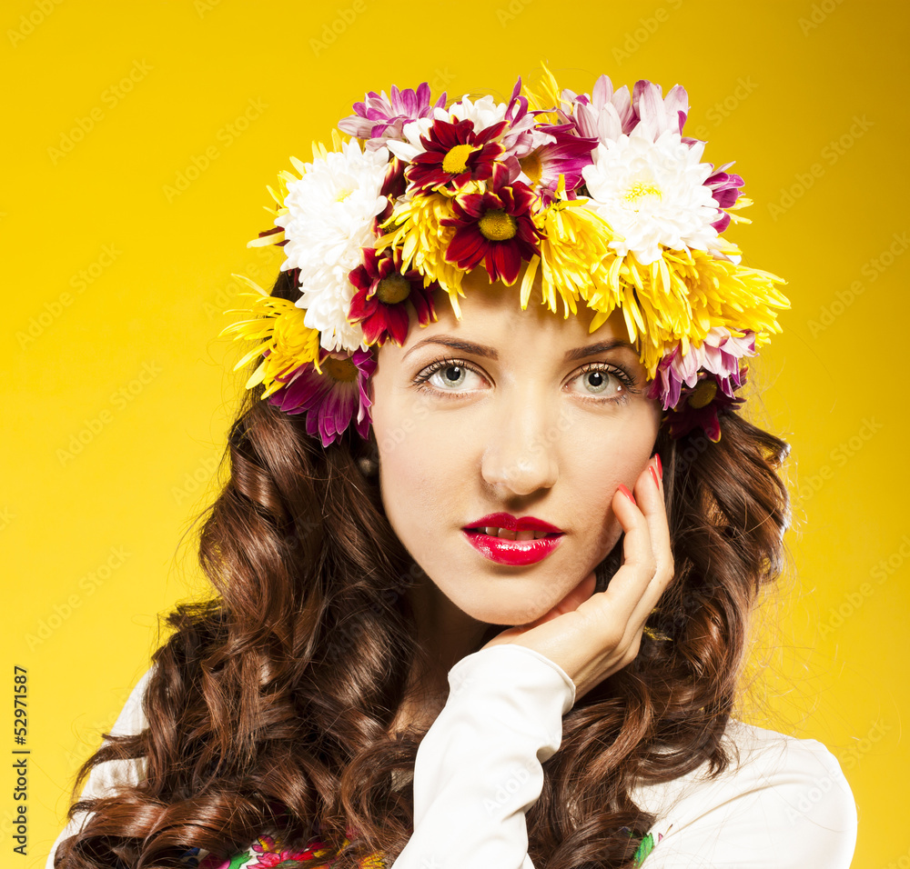Naklejka premium Portrait of beautiful spring woman, flowers hat. Studio shot