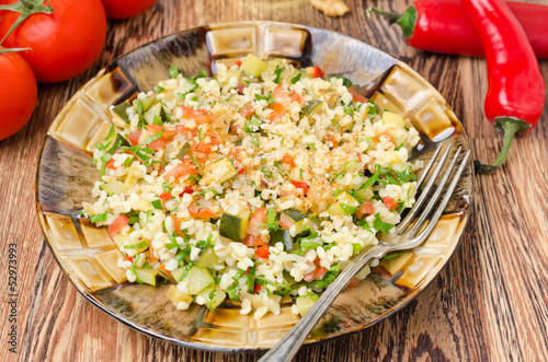 salad with bulgur, zucchini, tomatoes and parsley on the plate
