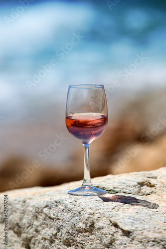 Verre de vin sur muret devant la mer