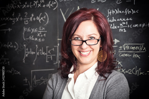 smiling caucasian female teacher blackboard background. school concept.