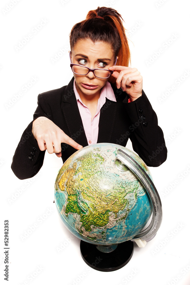 Businesswoman looking dumb pointing to a globe Businesswoman looking dumb pointing to a globe