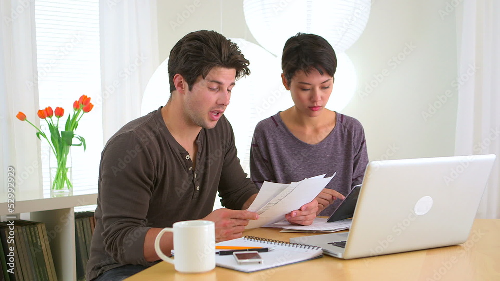 Mixed race couple looking over finances Mixed race couple looking over finances