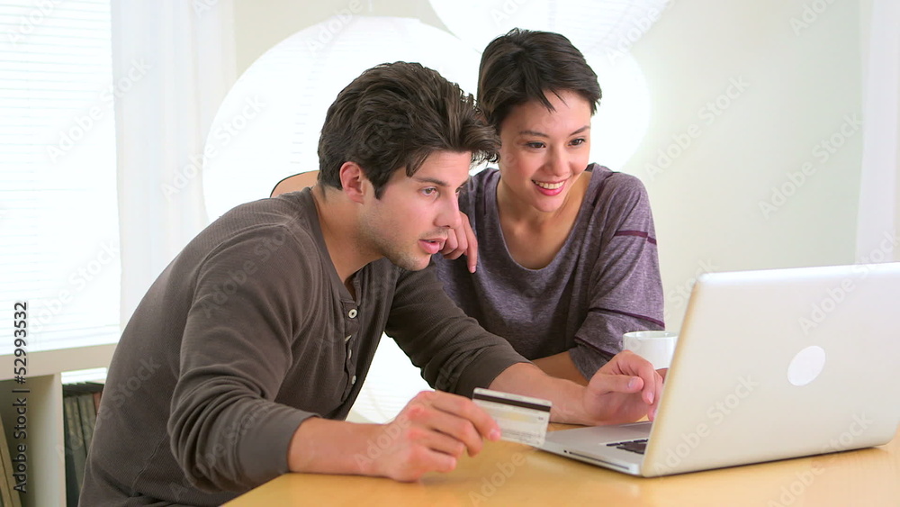 Chinese woman excitedly shopping online with boyfriend Chinese woman excitedly shopping online with boyfriend