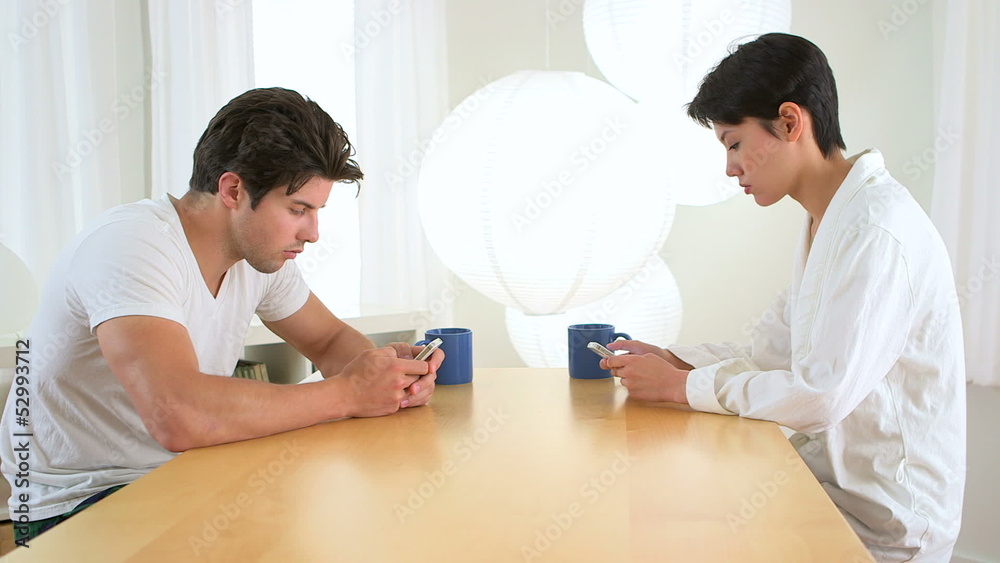 Man and woman distracted by their smartphones