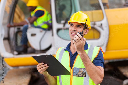 construction foreman talking on walkie-talkie photo
