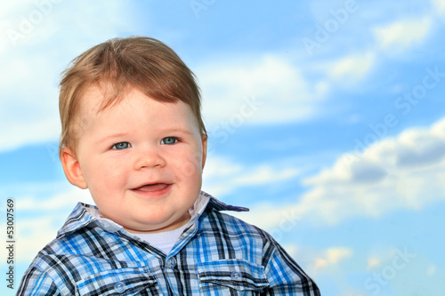 Smiling baby boy with blue eyes close up