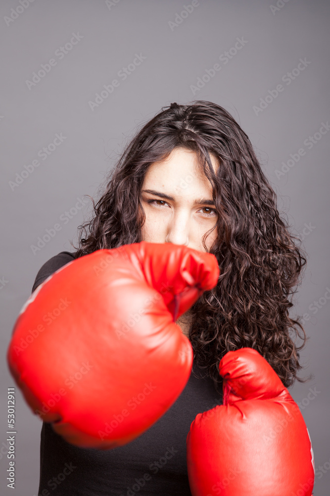 Beautiful woman thrusts a red boxing glove towards the camera.. Beautiful woman thrusts a red boxing glove towards the camera..