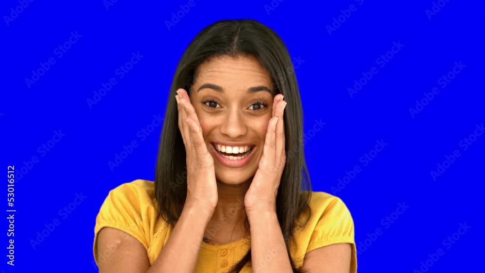 Surprised woman holding her head on blue screen