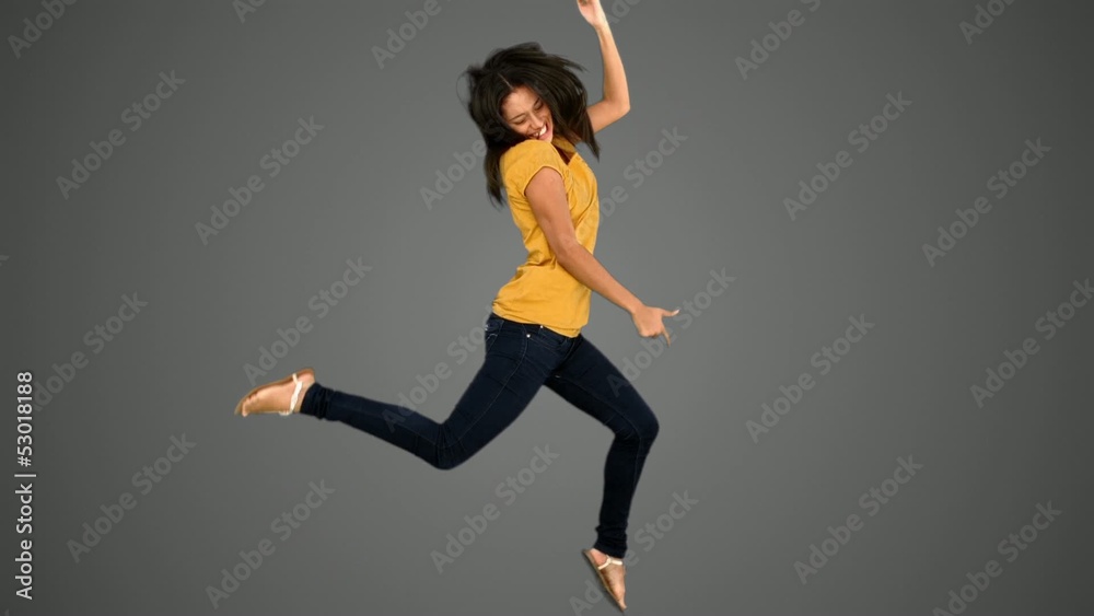 Woman jumping on grey background Woman jumping on grey background