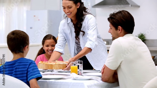 Mother bringing pizza to dinner table