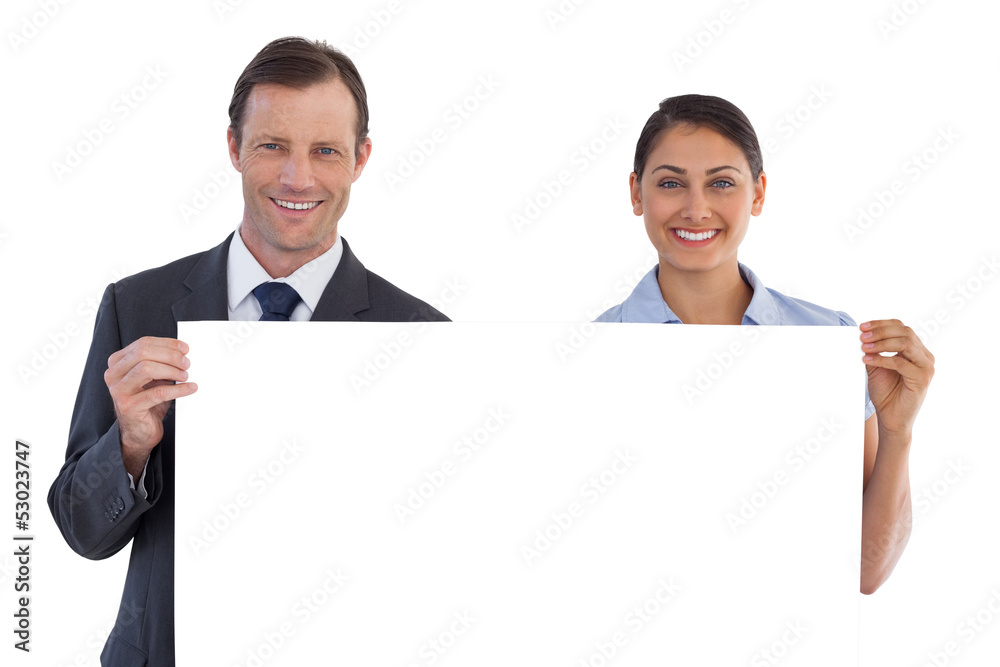 Smiling co workers holding a blank copy space Smiling co workers holding a blank copy space