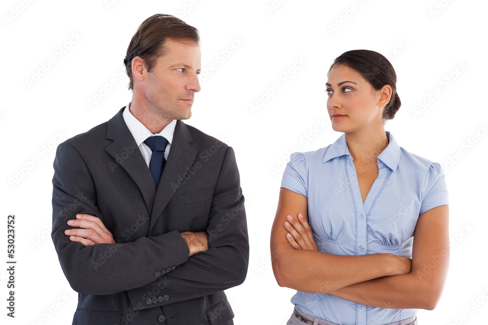 Smiling co workers looking seriously at each other Smiling co workers looking seriously at each other