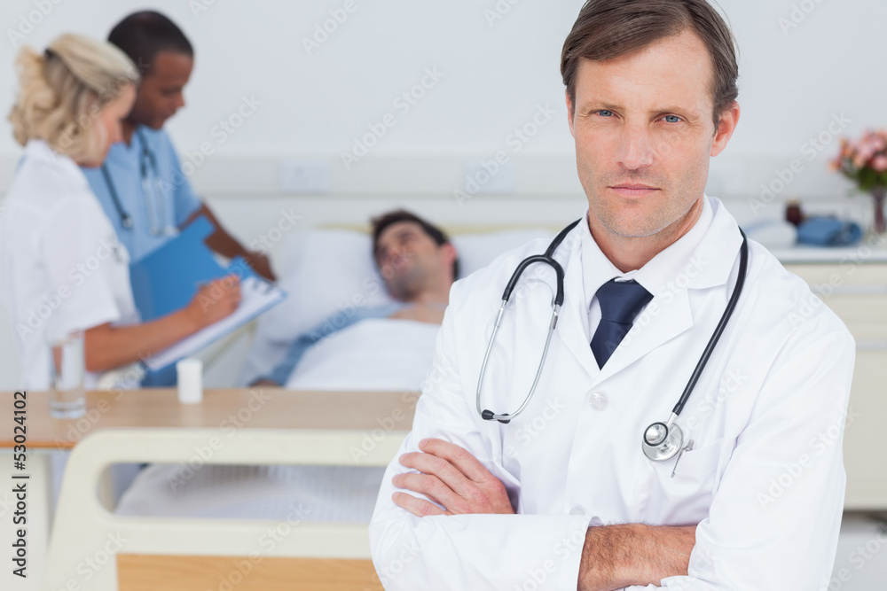 Fototapeta premium Serious doctor standing and looking at the camera