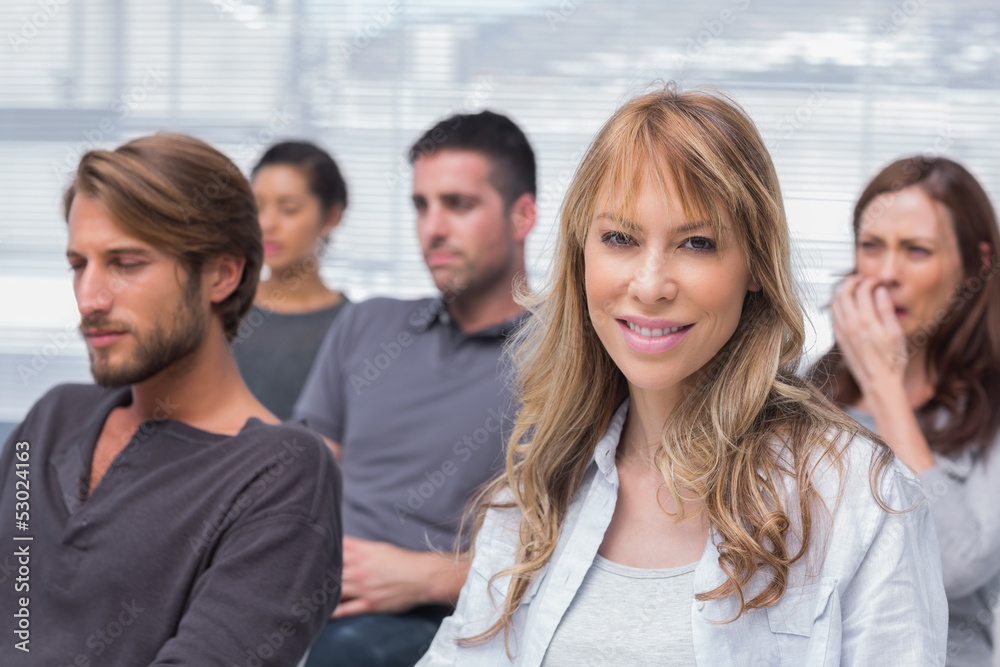Obraz premium Patients listening in group therapy with one woman smiling