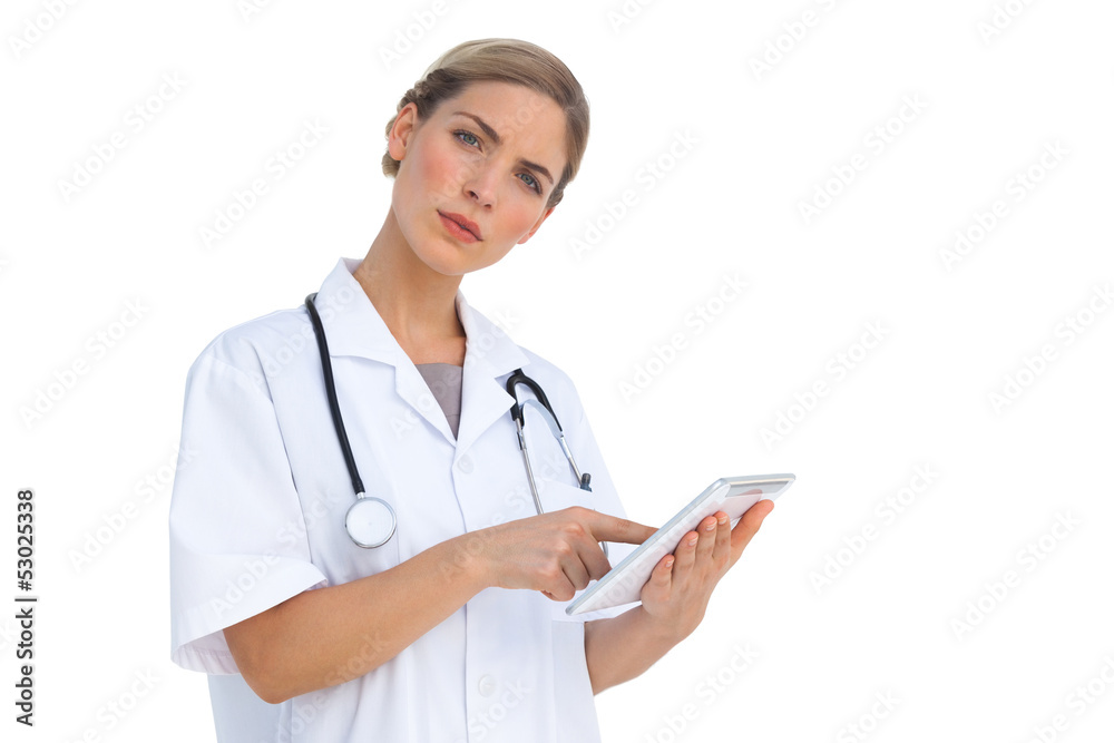 Serious nurse pointing something on tablet pc Serious nurse pointing something on tablet pc
