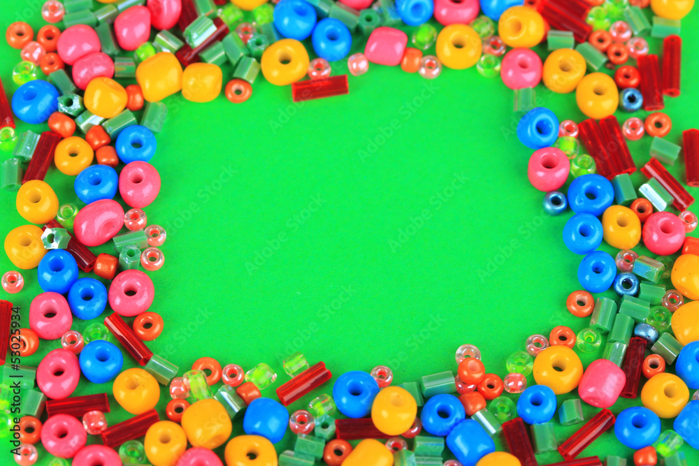 Different colorful beads on green background