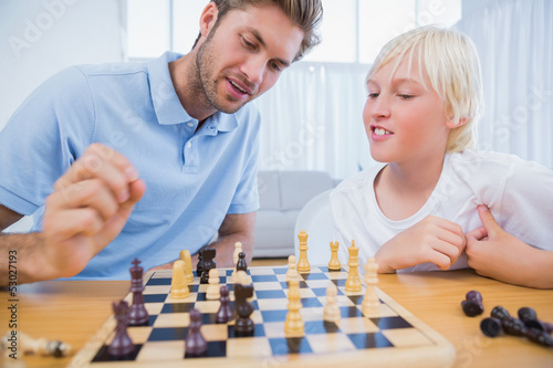 Father and his son playing chess together