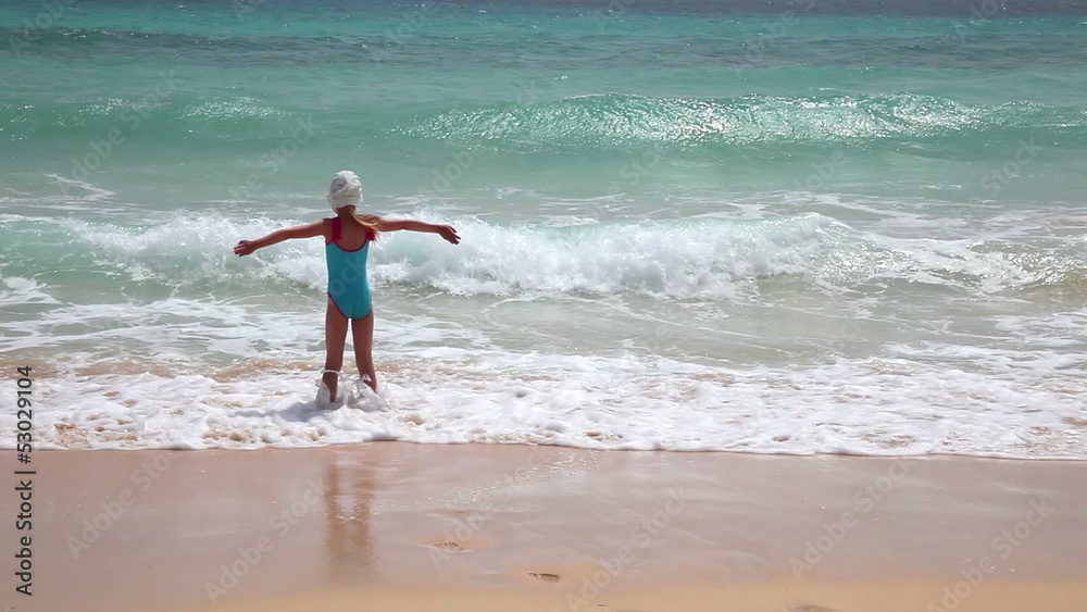 Young girl having fun with sea waves on beach, sunny beach Young girl having fun with sea waves on beach, sunny beach