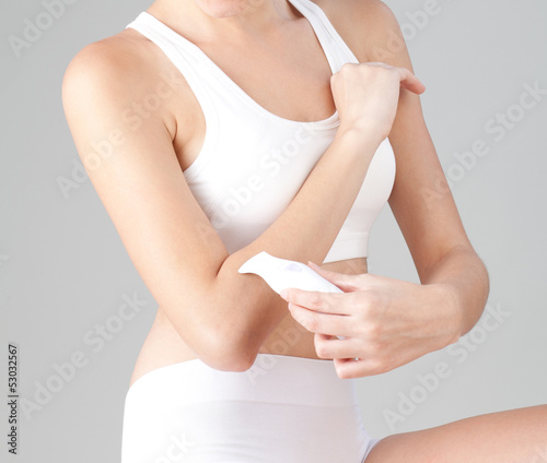 Woman trimming her arm with electric trimmer