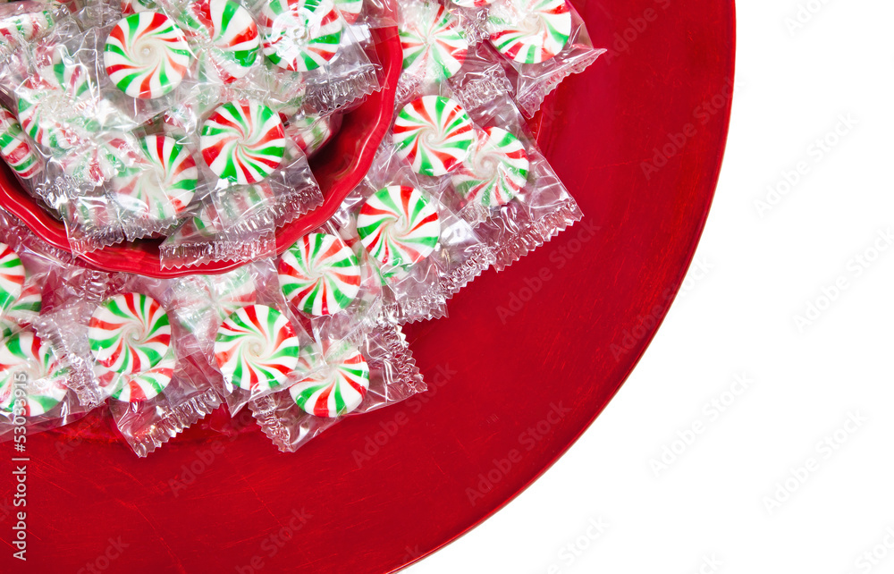 Peppermint Christmas candies on red plate over white