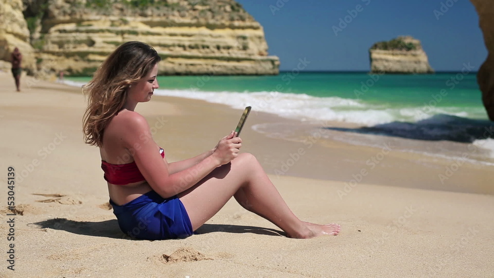 Young happy woman taking photo with tablet on the beach Young happy woman taking photo with tablet on the beach