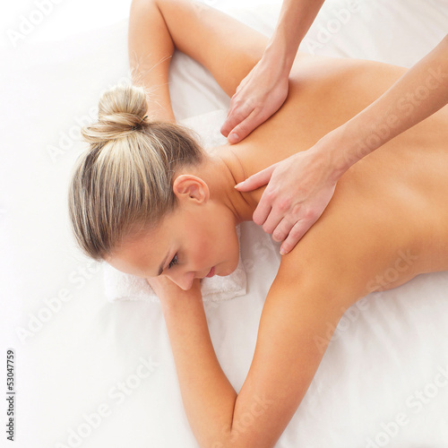 Young attractive woman getting massaging treatment over white ba