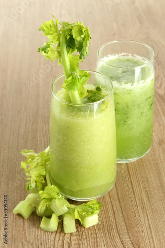 Glasses of celery juice on wooden background