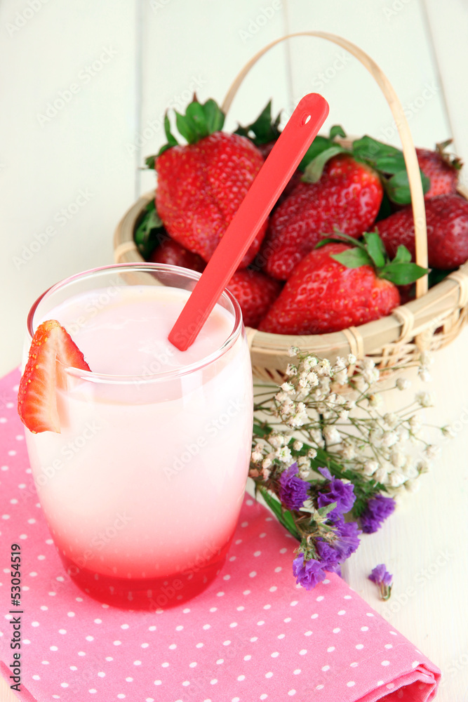 Delicious strawberry yogurt in glass on wooden table close-up