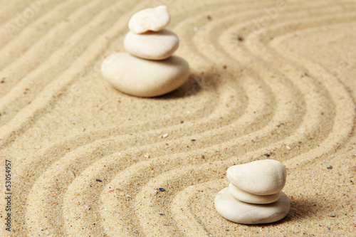 Zen garden with raked sand and round stones close up