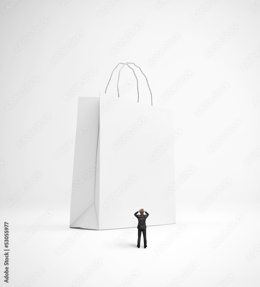 upset man looking at huge blank shopping bag upset man looking at huge blank shopping bag