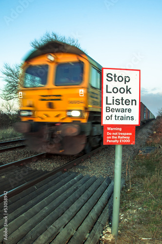 Beware of trains concept image with moving train in background