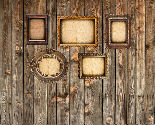 Set of empty picture frames on wooden wall