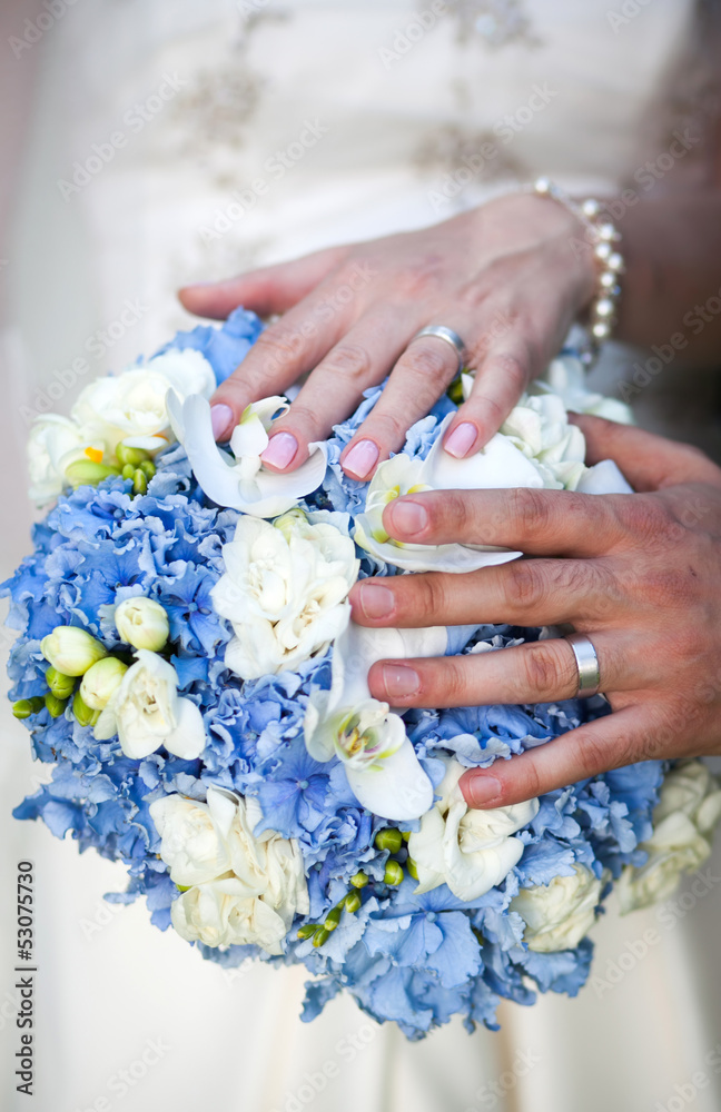 Fototapeta premium Hands and rings on wedding bouquet