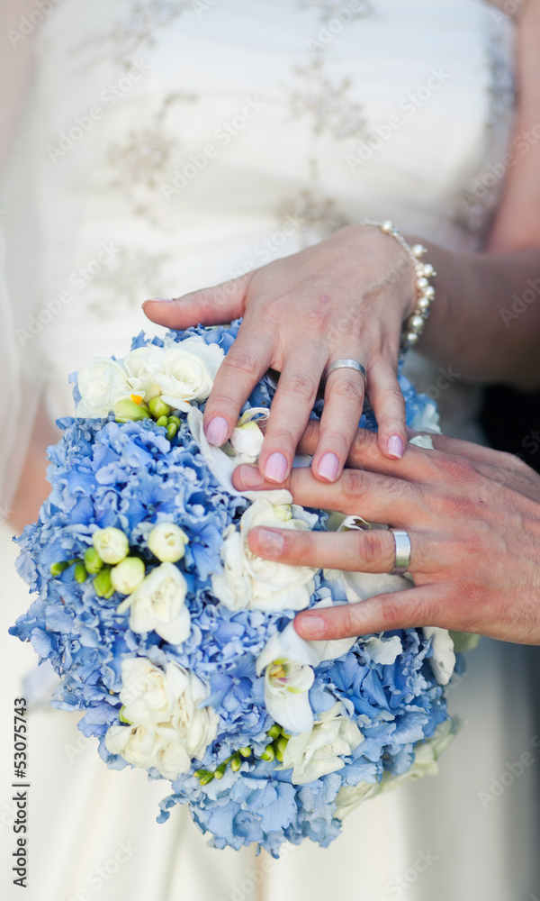 Fototapeta premium Hands and rings on wedding bouquet