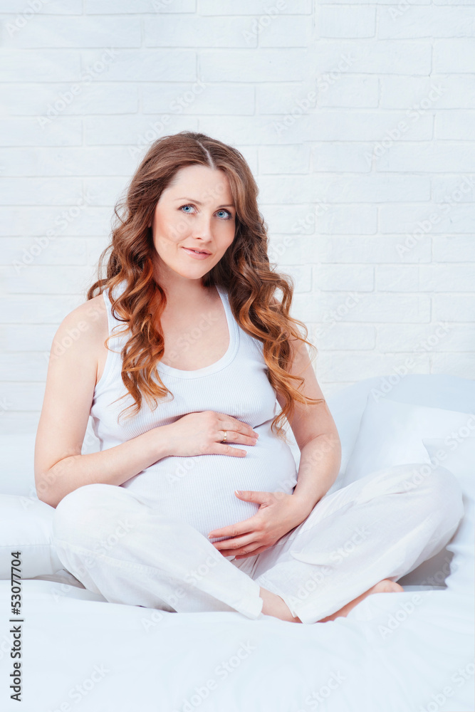 Pregnant woman sit on bed Pregnant woman sit on bed