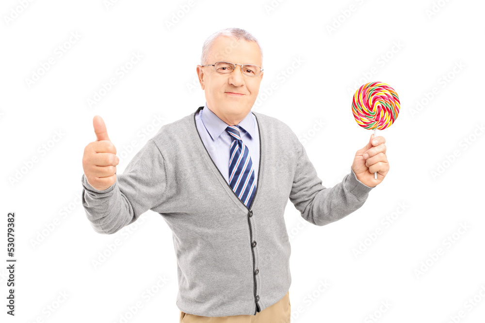 Smiling gentleman holding a colorful lollipop and giving thumb u Smiling gentleman holding a colorful lollipop and giving thumb u