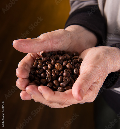 Old woman hands holding coffee beans